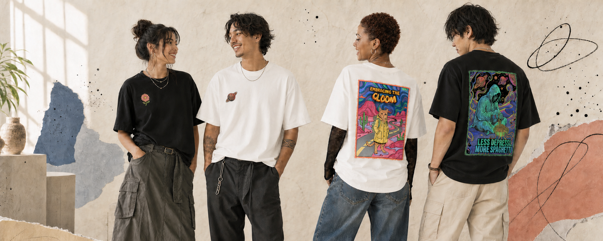 Four models wearing graphic t-shirts in a styled indoor setting with abstract wall art. The shirts include a black crewneck with a rose, a white crewneck with a small red graphic, a white t-shirt showing a large colorful back print, and a black t-shirt showing a large dark back print.